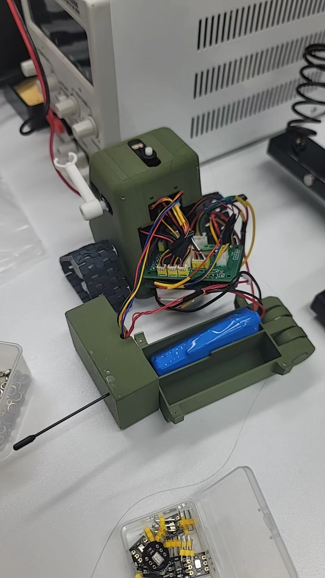 Green robot with internal wiring and electronics exposed during integration